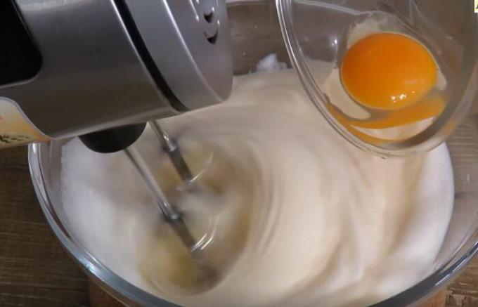 Selama busa protein kocok secara bertahap menambahkan kuning telur.