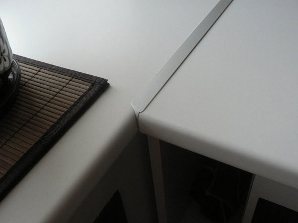 Celah antara dua bagian meja disembunyikan oleh strip logam