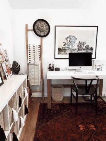 Ruang belajar rumah Boho Scandi dengan permadani boho, keranjang, tekstil cetak dan jumbai serta meja putih solid