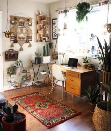 Kantor rumah Boho, sudut dengan meja ringan, macrame yang sedikit megah, tanaman dalam ruangan