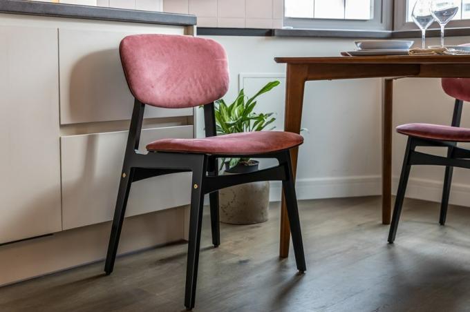 Mengakomodasi meja makan mengundang empat kursi yang terbuat dari kayu lapis birch dilapisi dengan enamel kelembaban-tahan, dengan punggung dan kursi berlapis dalam warna merah muda yang kaya.